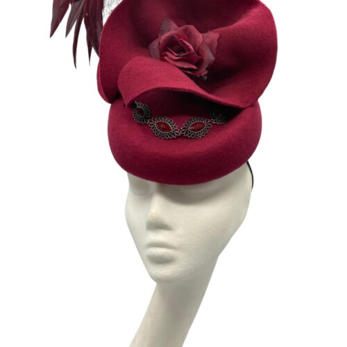 Burgundy/wine coloured pill box with veil and floaty feather detail.